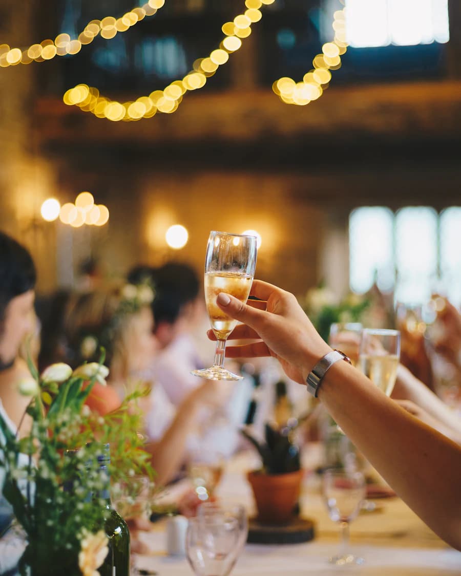 A candlelit dinner table set for friends, glasses raised mid-toast.
